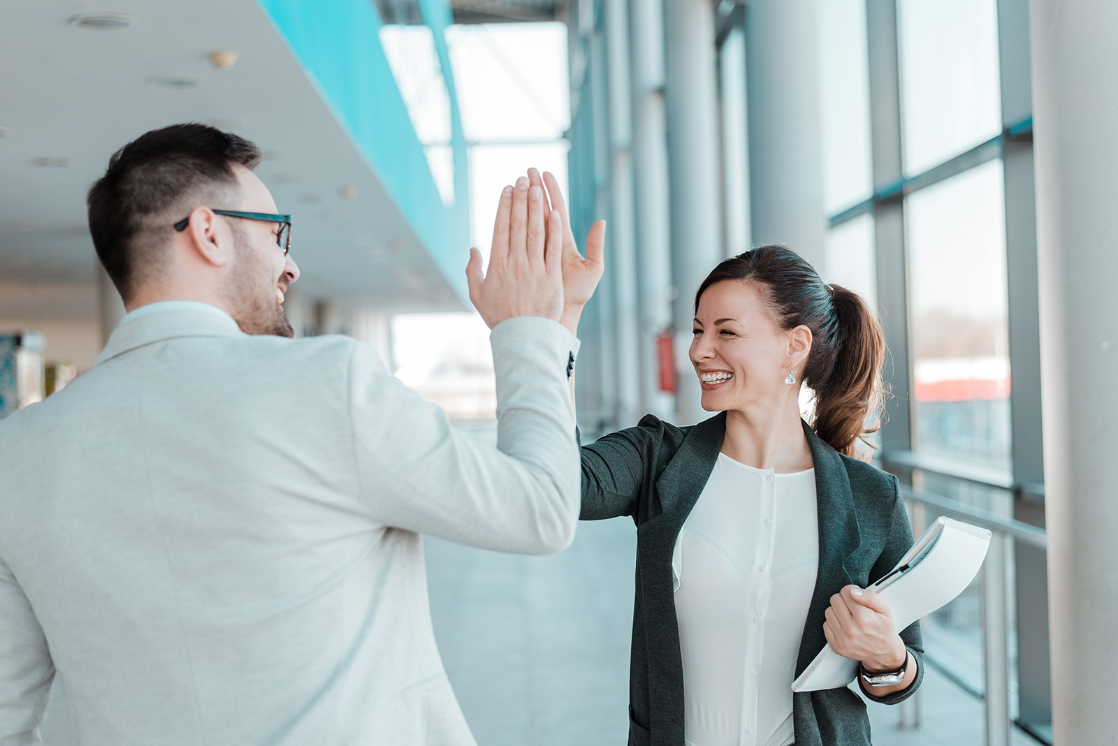 Two business people high-five. Job well done.